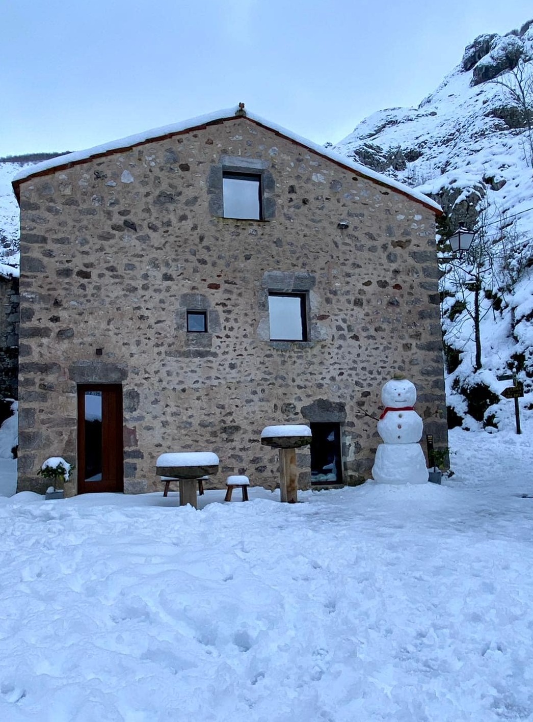 alojamiento rural La Aldea de Bulnes - exterior casa rústica con nieve - Picos de Europa